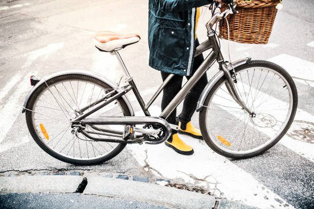 istock Young woman with bicycle in sunny spring town. 949370104