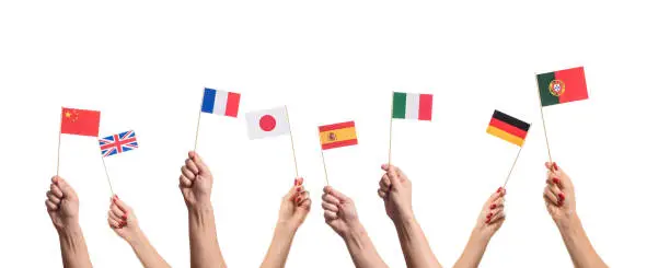 National flags of Germany, England, Italia, Japan, China Spain, France, Portugal in hands. Language studying concept on white background