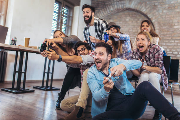 istock Coworkers playing video games in office 949371156