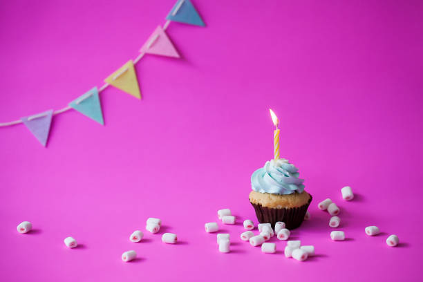 istock Birthday cupcake on pink background 949374604