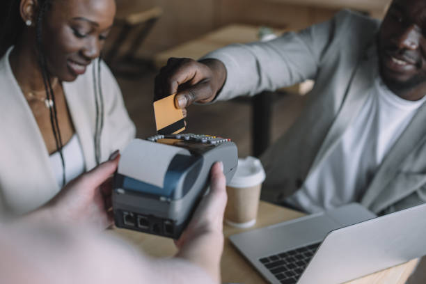 istock selective focus of african american man paying for order with credit card while spending time with friend in cafe 949377000