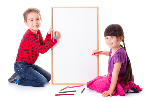 Pretty little girl and boy drawing on blank board
