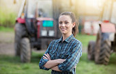 Farmer woman in front of tractors