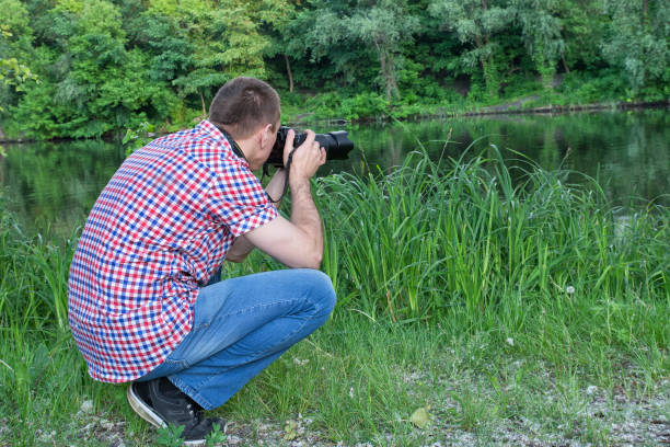 istock Photographer is shooting on the river bank 949386466