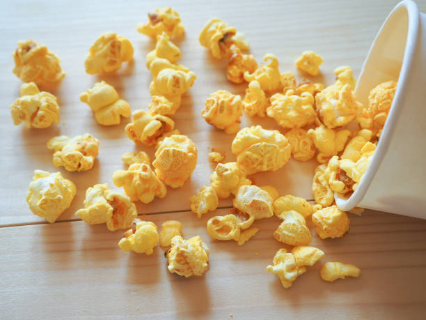 istock Sprinkled popcorn on a wooden table. 949389022