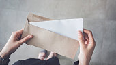 Stand up woman holding white folded a4 paper and brown envelope