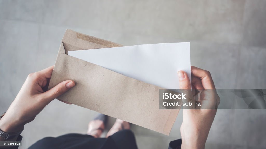 Stand up woman holding white folded a4 paper and brown envelope Letter - Document Stock Photo