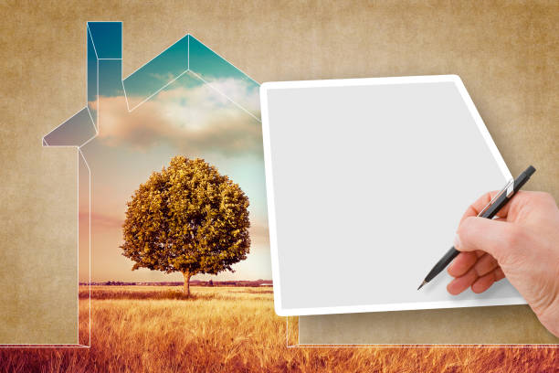 istock Hand writing on a blank sheet against a rural scene with a tree and a house outline - concept image with copy space 949403312