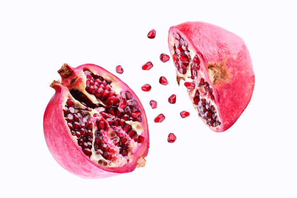 istock Pomegranate in flight burst on a white background, isolated. Cut half pomegranate flying in the air. Pomegranate fruit explosion 949403604