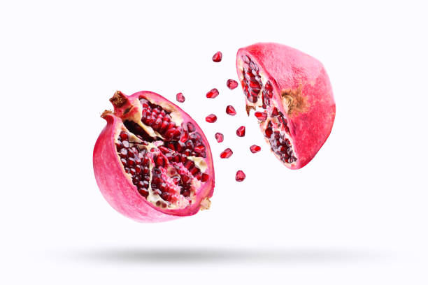 istock Pomegranate in flight burst on a white background, isolated. Cut half pomegranate flying in the air. Pomegranate fruit explosion 949403678