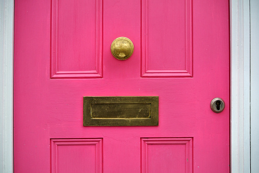 detail of pink door with letterbox,