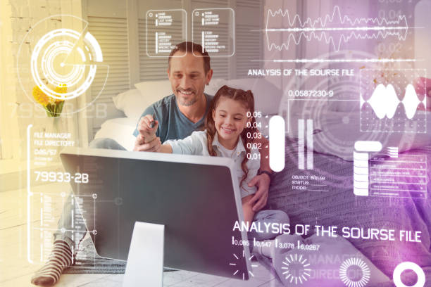 istock Positive parent smiling while helping his daughter with new technologies 949421518