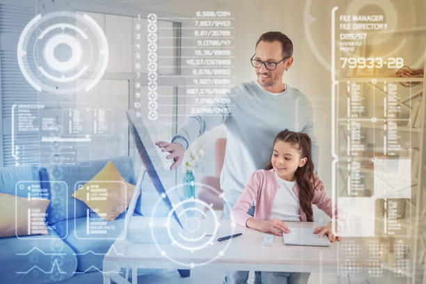 istock Positive father smiling while helping his hardworking daughter with homework 949425896