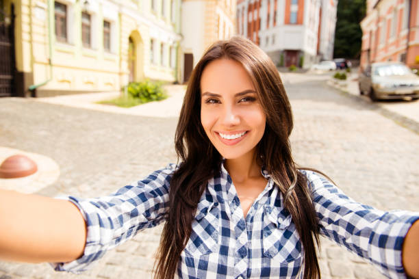 istock Beautiful young runette with beaming smile making selfie 949430092
