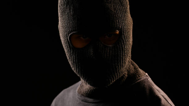 istock The robber looking at the victim on black background 949430438