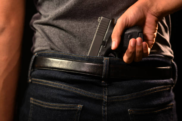 istock The man concealing gun behind his back 949430676