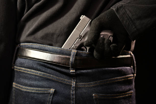 istock The man concealing gun behind his back 949430690