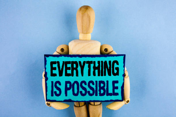 istock Text sign showing Everything Is Possible. Conceptual photo All you think or dream can become true Optimistic written on Sticky note paper holding by Wooden Robot Toy on the plain background. 949431618