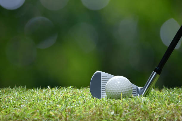 istock Golf ball on green grass ready to be struck on golf course background 949432298