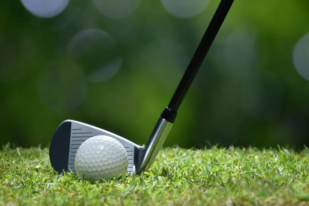 istock Golf ball on green grass ready to be struck on golf course background 949432320