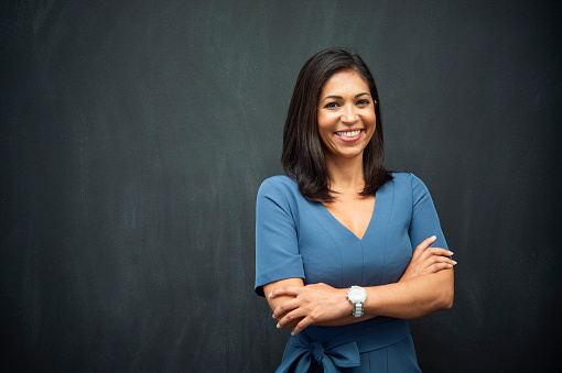 Hispanic woman with chalk board background for copy space.