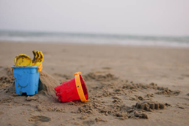 istock red and blue toy bucket for kid on sand beach 949443330