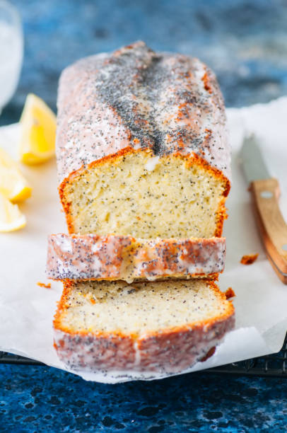 istock Sliced lemon poppy seed pound cake covered with a glaze on a wire rack. Blue stone background. Close up 949443902