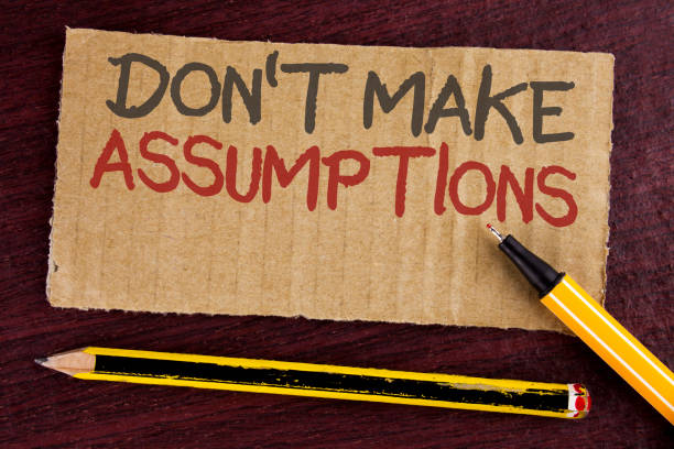 istock Text sign showing Do not Make Assumptions. Conceptual photo predict events future without clue Alternative Facts written on Cardboard Piece on wooden background Led Pen and Pencil next to it. 949446494