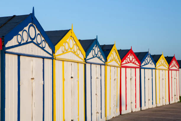 istock Seaside resort beach huts. Row of retro brightly colored sheds 949446750