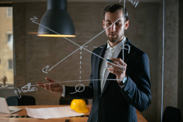 istock Businessman drawing graph on glass wall 949450740