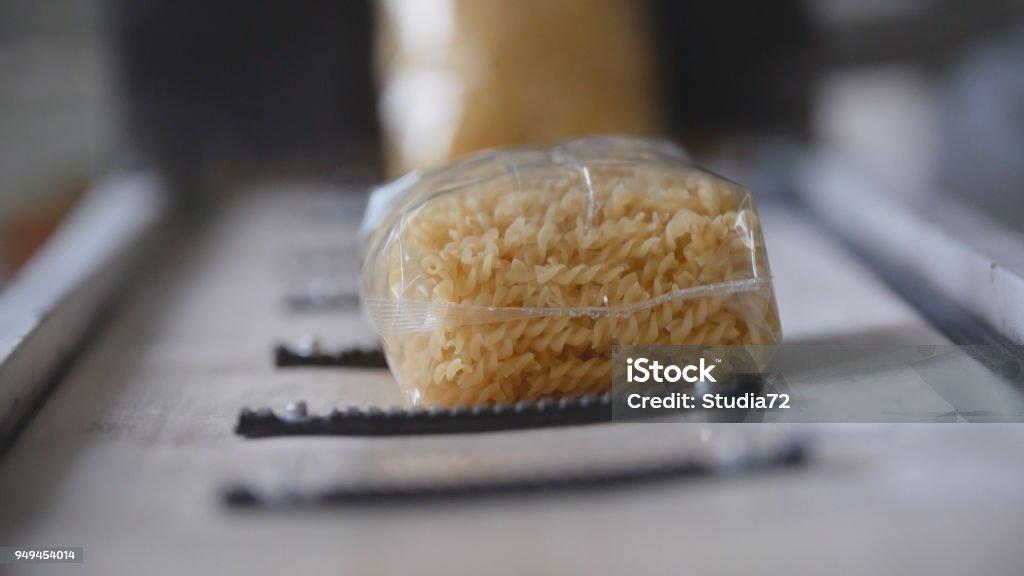 Food industry - conveyor with plastic pack of macaroni Food industry - conveyor with plastic pack of macaroni, panoranic Pasta Stock Photo