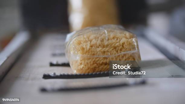 Food Industry Conveyor With Plastic Pack Of Macaroni Stock Photo - Download Image Now