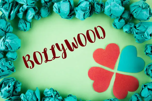 Photo of Handwriting text Bollywood. Concept meaning Indian cinema a source of entertainment written on plain background within Paper Balls Hearts next to it.