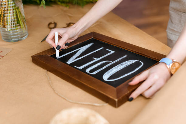 istock close-up partial view of young florist writing word open with chalk on board 949456654