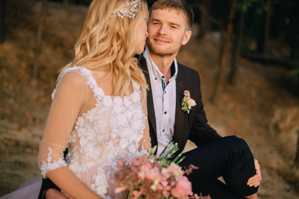 istock newlyweds sitting on the lake and looking at each other 949456700