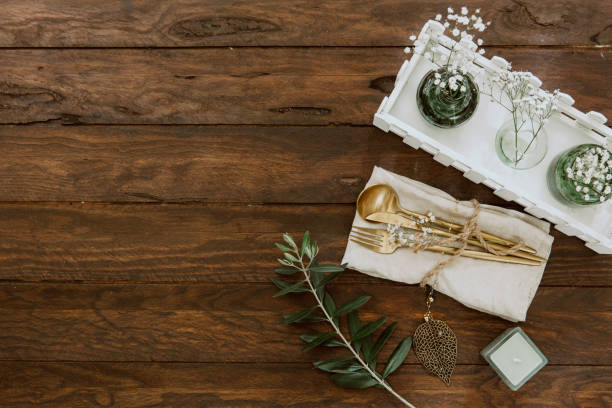 istock Rustic table setting on wooden table: gold vintage silverware, linen napkin and olive brunch. Romantic or wedding concept 949456784