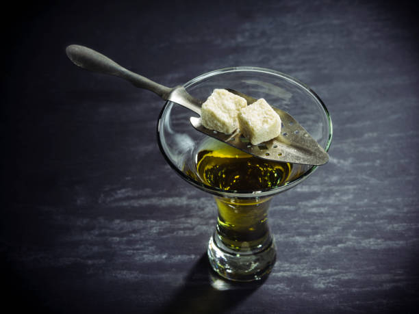 Glass of Absinthe with sugar cubes and spoon Photo of a glass of absinthe with spoon and sugar cubes. absinthe spoon stock pictures, royalty-free photos & images