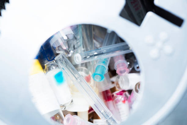 istock Used needles, glass of injected drug in container 949457868