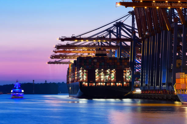 istock Big Container ship in the harbor at night, Hamburg 949459138