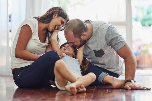 Family time is a fun time Shot of a mother and father bonding with their adorable young daughter at home sitting on floor stock pictures, royalty-free photos & images