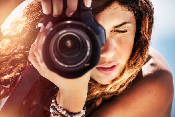 Beautiful girl with camera on the beach