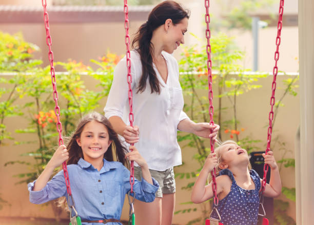 istock Mother with two daughters on playground 949464016