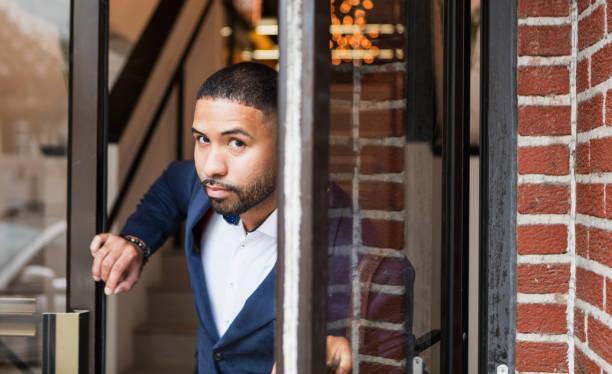 istock Mixed race man opening exterior door, leaving work 949466534