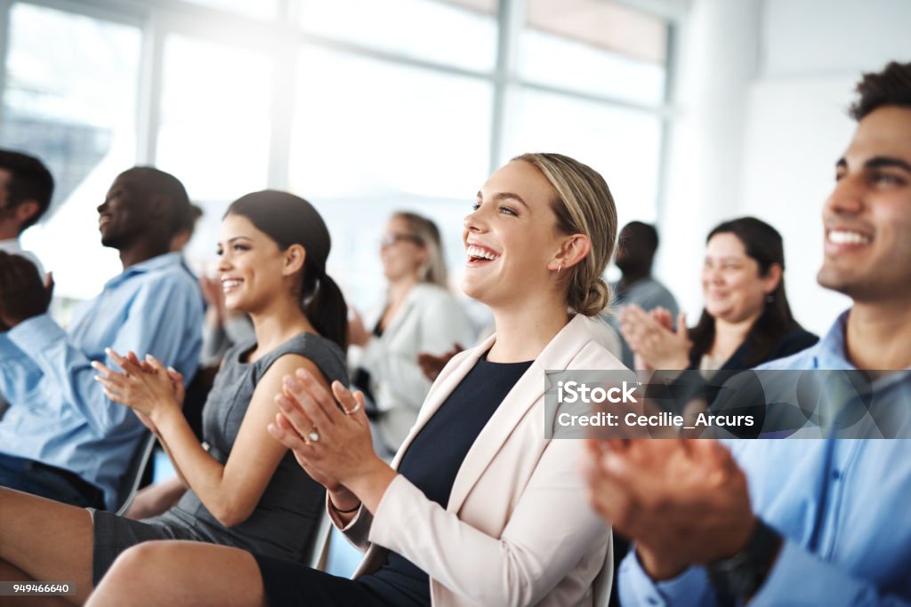 Now that's something to get excited about Cropped shot of a group of businesspeople applauding while sitting in a lecture room during a seminar Meeting Stock Photo