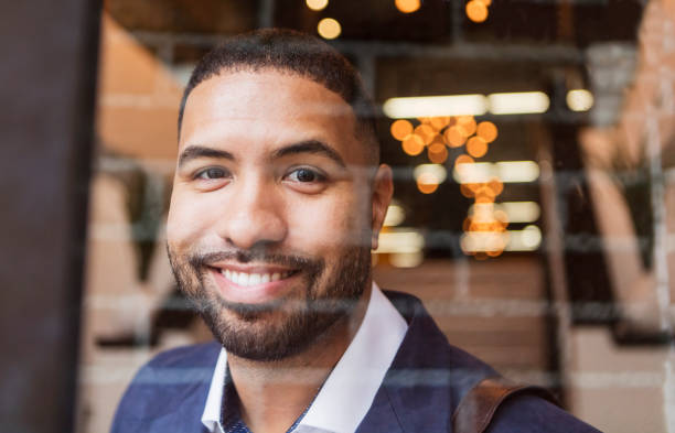istock Mixed race man leaving work, looking through glass door 949466812