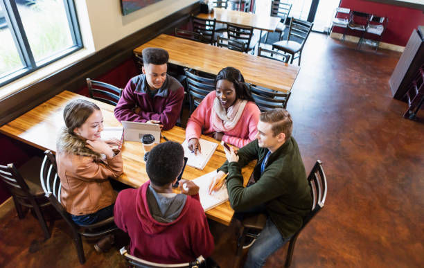 Teenagers studying together in coffee shop