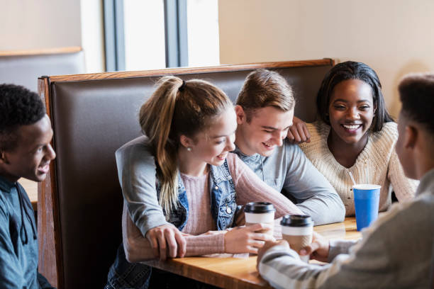 istock Five teenagers sitting in restaurant booth, conversing 949470298