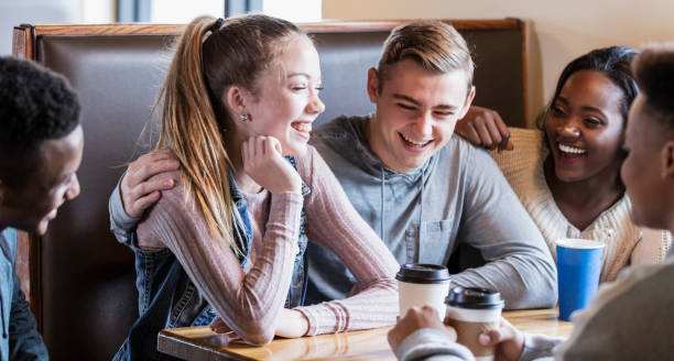 istock Five teenagers sitting in restaurant booth, conversing 949470466
