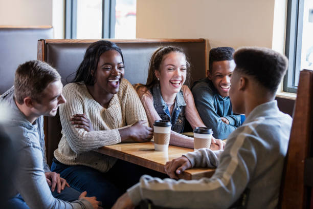istock Five teenagers sitting in restaurant booth, conversing 949470468