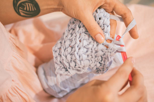 istock knitting crochet process close up. Hands with knitwork. Warm toned photo 949470566